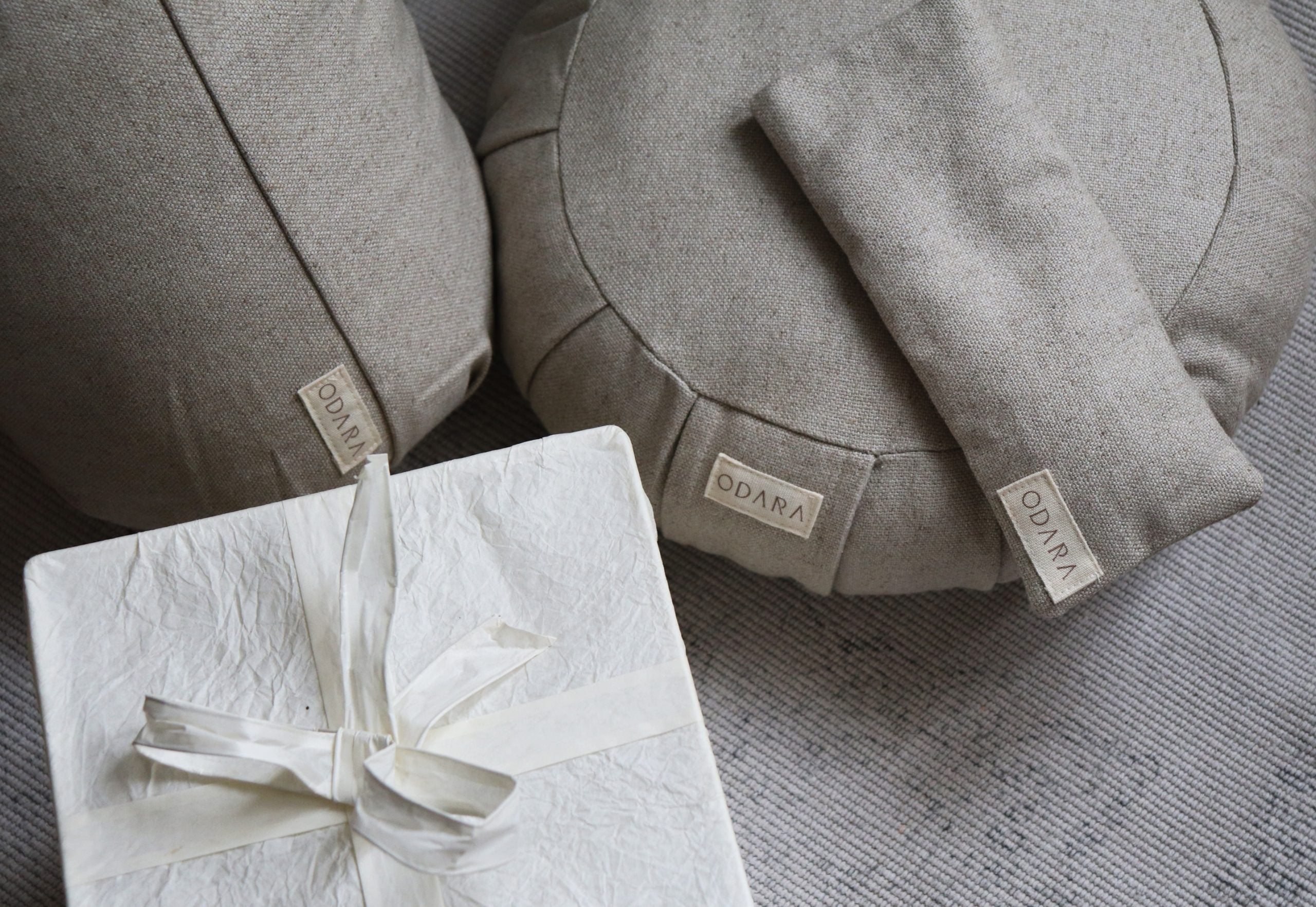 Handmade natural fabric meditation cushions, eye pillow, and gift box on textured mat